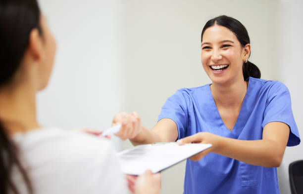 A nurse smiling collecting paperwork