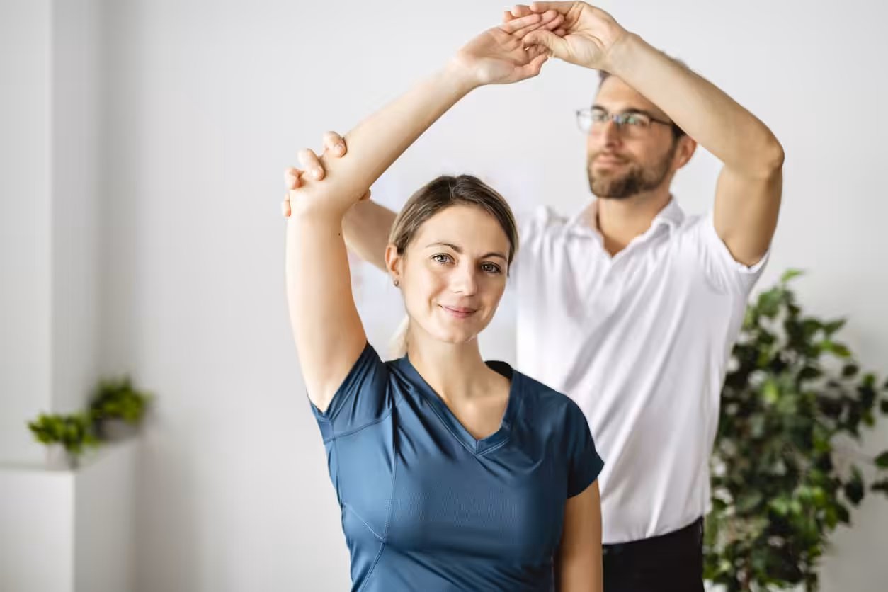 A male doctor stretching a females shoulder